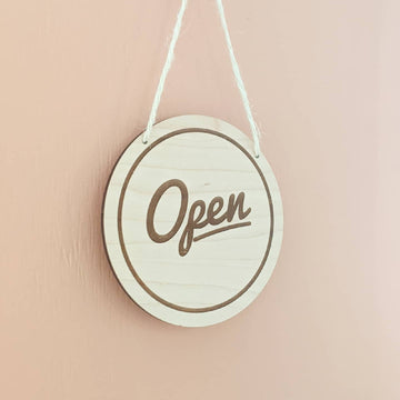 Open sign in maple with a pink background
