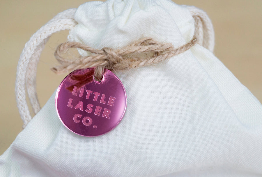 Pink acrylic tags on calico bag